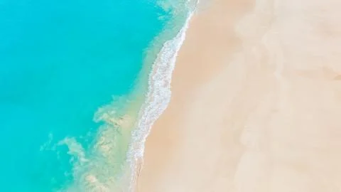 Summer seascape with soft waves rolling onto a sunlit white sandy shore Stock Photos