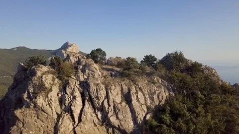 Summer seashore with mountains and forest appears from the cliff 스톡 동영상 102716780