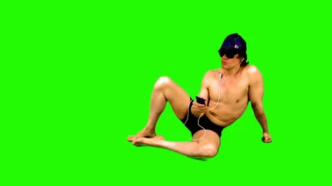 Summer season. Sunbathing athletic guy on a green background. Stock Footage 106950115