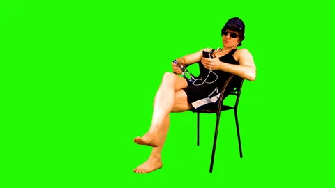 Summer season. Sunbathing athletic guy on a green background. Video stock 107807779
