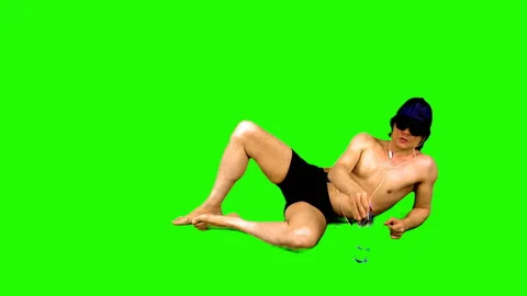 Summer season. Sunbathing athletic guy on a green background. 스톡 동영상 107807909