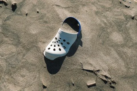 Summer slipper trash on wild polluted sea coast ecosystem after sea storm,italy Stock Photos
