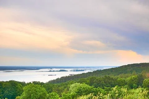 Summer spring evening river Dniper flowing among flowering green hills. Stock Photos