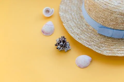 Summer straw hat beach with seashells on yellow background.Summer accessories Foto stock