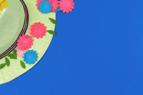 Summer straw hat flat lay composition with paper flowers on a blue background Stock Photos
