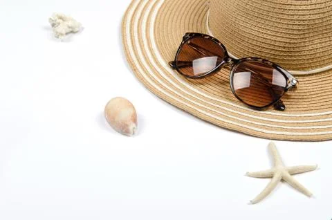Summer straw hat, sunglasses, shells, starfish on white background. Stock Photos