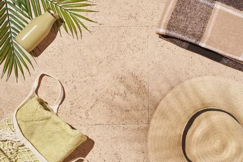 Summer sun beach concept flat lay.Hat, string bag with towel and bottle, leaves Stock Photos