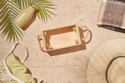 Summer sun beach concept flat lay.Hat, string bag with towel and wooden box Stock Photos