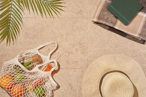 Summer sun beach concept flat lay.Hat, string bag with fruits and lemonade Stock Photos