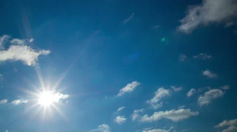 Summer sun shining in blue sky with white clouds time lapse with lens flare 4k Stock Footage 46737522