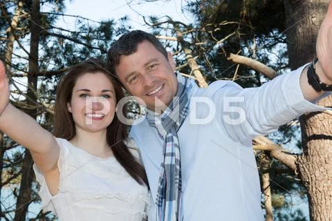 Summer Sunny Couple Portrait On A Background Of Blue Water On The Beach. Doin