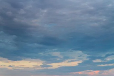 Summer sunset in the cloudy sky above the sea Stock Photos