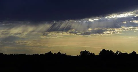 Summer sunset, dark clouds in the sky hide the sun. Good weather is not promi Stock Photos