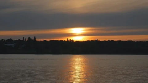 Summer sunset similar to a flash on the background of a calm river Stock Footage 119703288