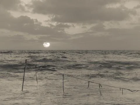 Summer sunset view of a beach under a cloudy sky in black and white Stock-Fotos