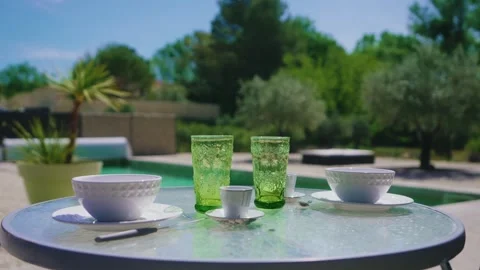 Summer Table Setting with Green Embossed Glasses Near Pool and Olive Trees Stock Footage 331070620