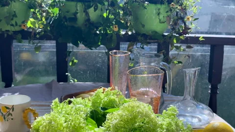 Summer table setting on a sunny veranda. Rustic yet elegant. A woman places ice  Stock Footage 312408426