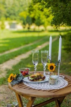 Summer table with wine and snacks fruit and croissants rustic landscape Stock Photos