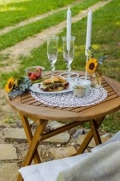 Summer table with wine and snacks fruit and croissants rustic landscape Stock Photos