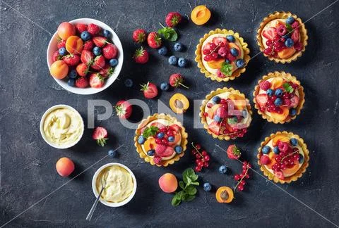 Summer tartlets with fresh custard cream, berries Stock Photos