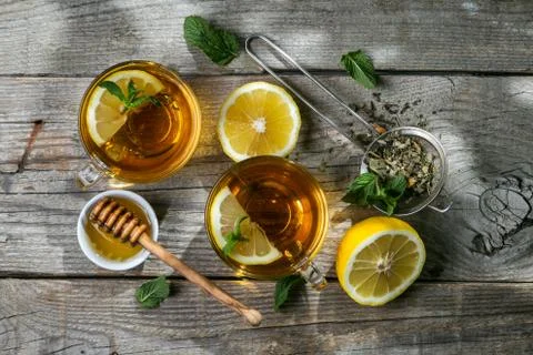 Summer tea - tea cups on rustic wood background with leaves shades - garden Stock Photos