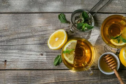 Summer tea - tea cups on rustic wood background with leaves shades - garden Stock Photos