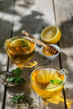 Summer tea - tea cups on rustic wood background with leaves shades - garden Stock Photos
