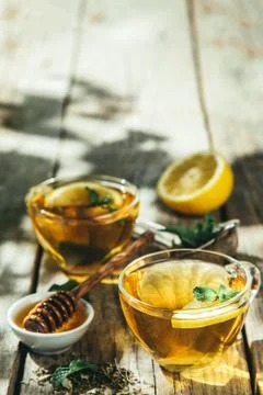 Summer tea - tea cups on rustic wood background with leaves shades - garden Stock Photos