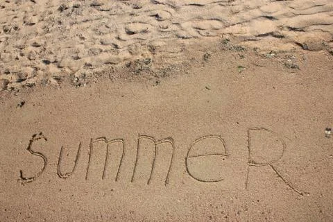 Summer text is written on sand Stock Photos