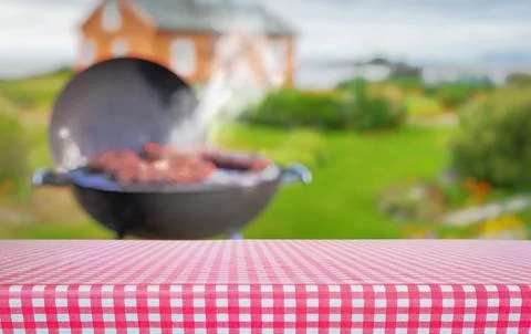 Summer time in backyard garden with grill BBQ, table with red checkered clo.. Stock Photos