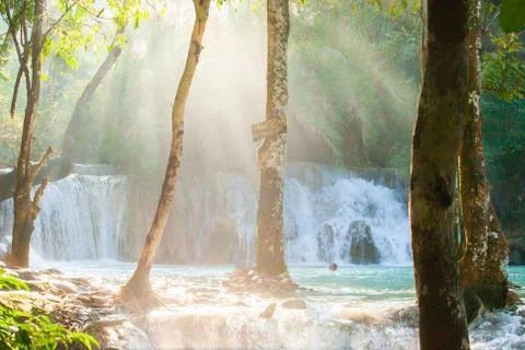 Summer time, Light beams through tropical trees around the waterfall and tour Stock Photos