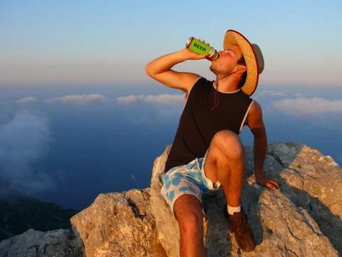 Summer time, a man drinking beer in the mountains Foto stock