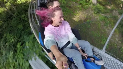 Summer toboggan run rodelbahn with many curves on a mountain. Alpine coaster. Stock Footage 139649953