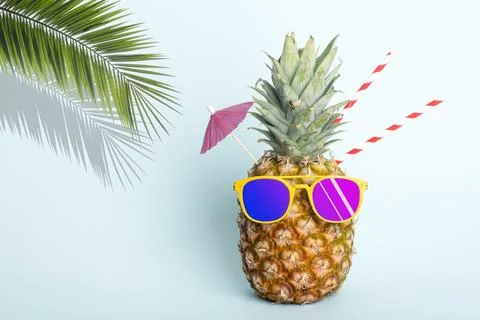 Summer tropical pineapple background. Pineapple in sunglasses under a palm tree Stock-Fotos