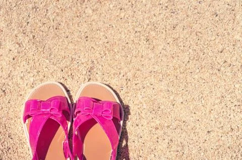 A Summer vacation background with a pair of sandals on beach Stock Photos