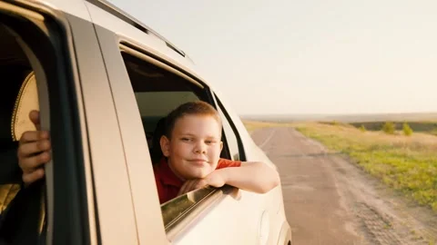 Summer vacation, child boy catching wind with hand, back seat car, enjoying Stock Footage 265023261