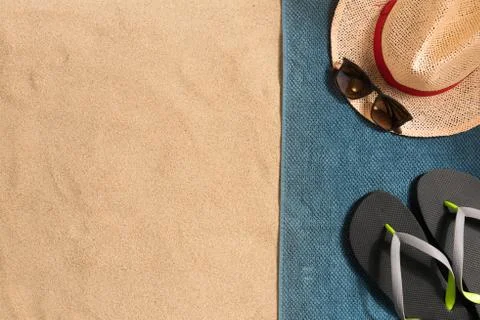 Summer vacation composition. Flip flops, hat and sunglasses on sand backgroun Stock Photos