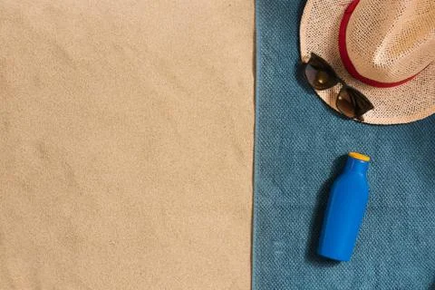 Summer vacation composition. Hat, sun cream and sunglasses on sand background Stock Photos