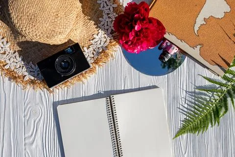 Summer vacation concept flat lay. Straw hat, film camera, world map on white Stock Photos