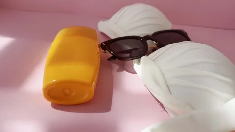 Summer vacation essentials featuring a white bikini, black sunglasses, and .. Vídeos de archivo 334617501