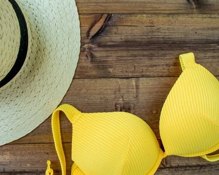 Summer vacation, flatlay. Hat and swimsuit on a dark wooden background. Stock Photos