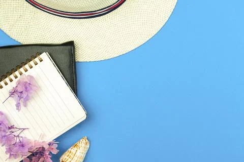 Summer vacation notebook, diary concept, tropical hat and sea shells on blue  Stock Photos