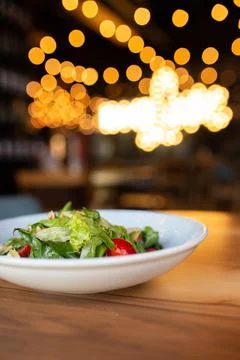Summer vegetable salad with herbs on the table in the restaurant Stock Photos