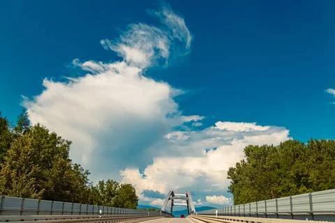  Summer view with a bridge and dramatic clouds near Plattling, Isar, Degge... Foto stock