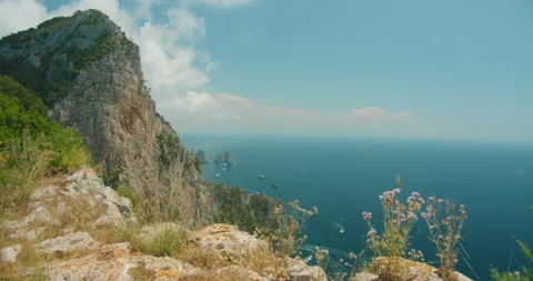 Summer view from Capri cliff overlooking Faraglioni rock and Tyrrhenian sea in Stock Footage 345535052
