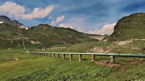Summer View of a Green Valley with Pipeline and Mountain Background Stock Footage 306156232