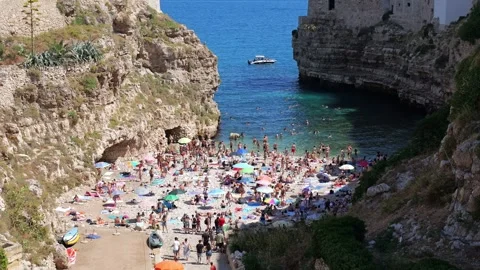 Summer view of Polignano a Mare with a crowded beach,Italy, 19 july, 2025 Stock Footage 315334964