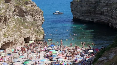 Summer view of Polignano a Mare with a crowded beach Stock Footage 315335600