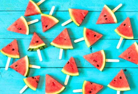 The summer watermelon slice popsicles on a blue rustic wood background Stock Photos