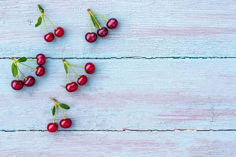 Summer welcome card format flat lay cherry sprig on blue wooden background Stock Photos
